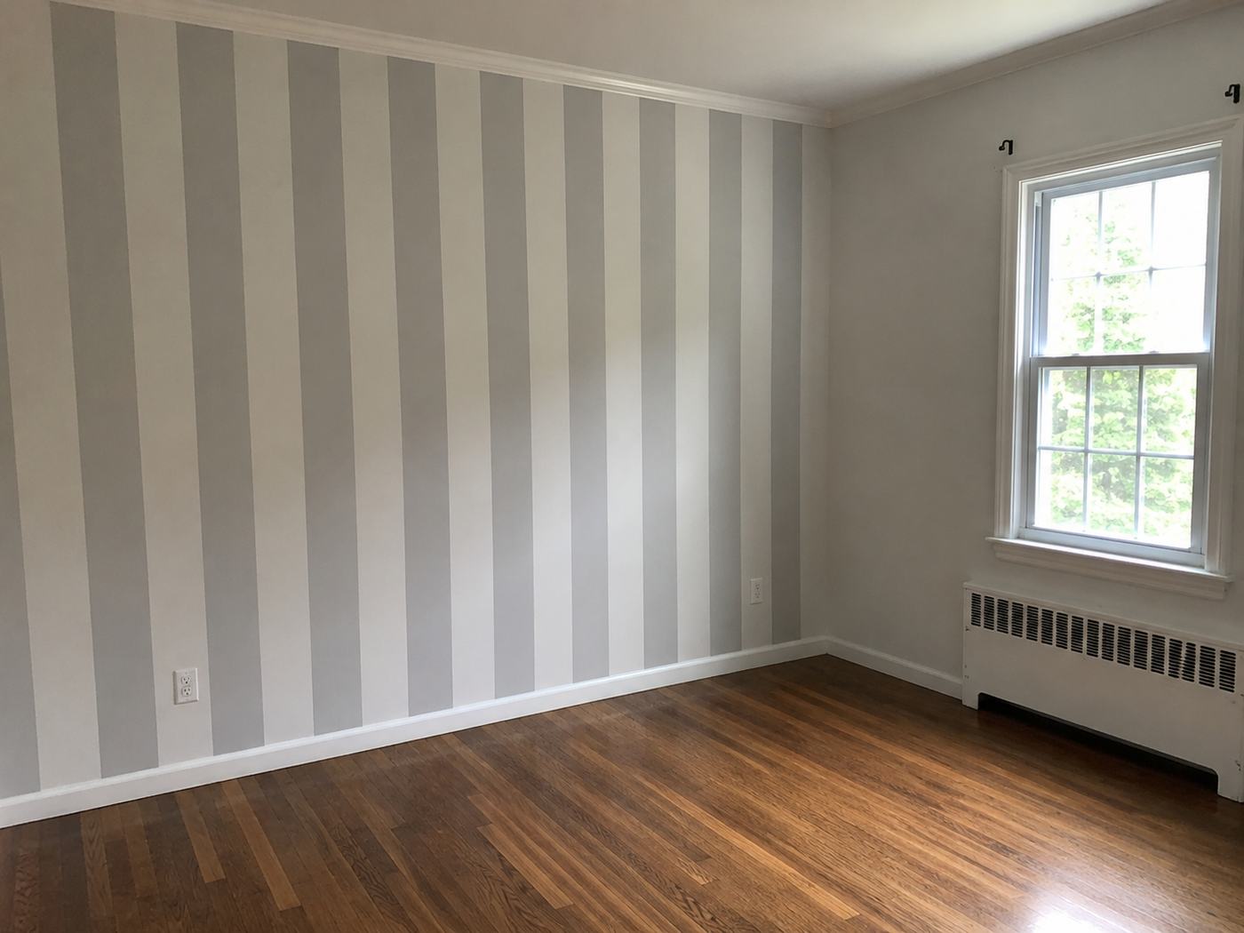 Painted grey and white striped accent wall in a bedroom