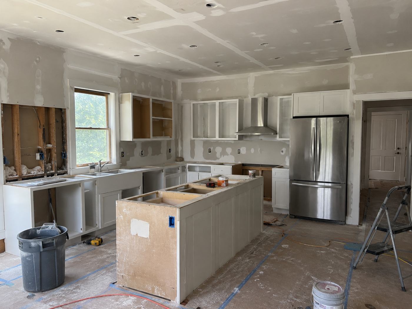 Kitchen renovation with new cabinetry, exposed framing and island under construction